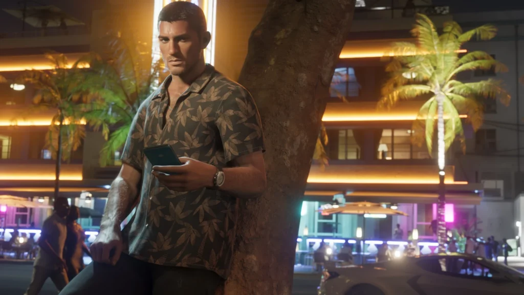 Jason holds a phone beside a tree on a neon-lit street at night.