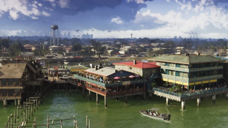 Waterfront buildings on pilings overlook a motorboat and distant city skyline.